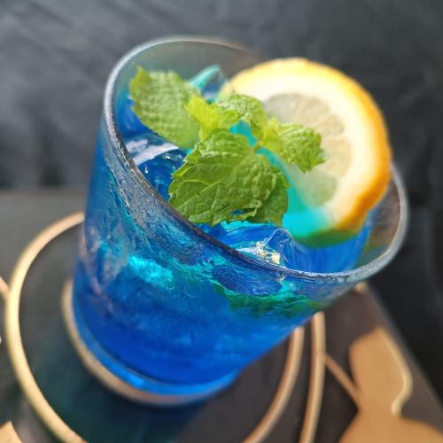 a blue drink with a lemon and a piece of mint at Swiss-Belinn SKA Pekanbaru in Pekanbaru