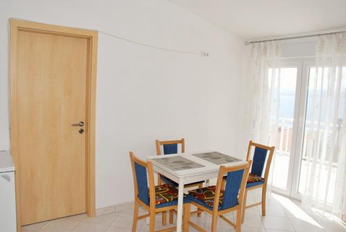 uma sala de jantar com uma mesa e cadeiras e uma janela em Apartments with a parking space Lokva Rogoznica, Omis - 17395 em Lokva Rogoznica