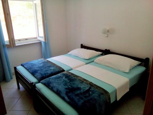 2 camas individuais num quarto com uma janela em Apartments with a parking space Lokva Rogoznica, Omis - 17395 em Lokva Rogoznica