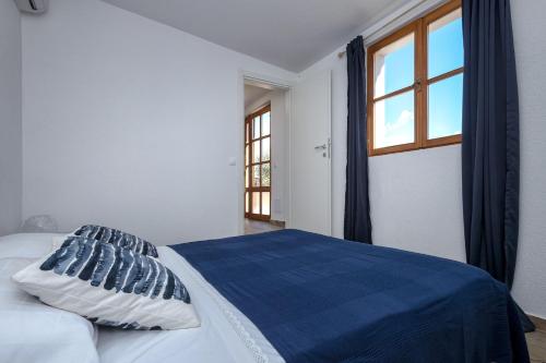 Schlafzimmer mit einem Bett mit blauer Bettwäsche und einem Fenster in der Unterkunft Holiday house with a parking space Pitve, Hvar - 17397 in Jelsa