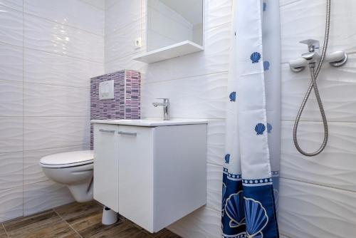 a white bathroom with a toilet and a sink at Holiday house with a parking space Pitve, Hvar - 17397 in Jelsa