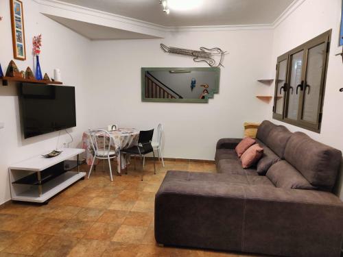 a living room with a brown couch and a table at Casa vacacional Renacer in Gran Tarajal