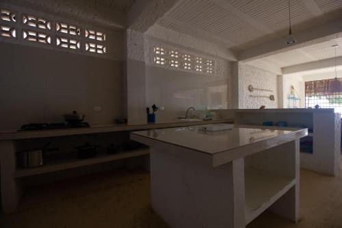 a large white kitchen with a large counter top at Cabaña CasaMare in Rincón