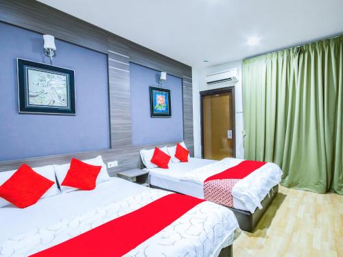 1 dormitorio con 2 camas y almohadas rojas y blancas en Super OYO Capital O 812 Hotel SMC Seksyen 13 en Shah Alam