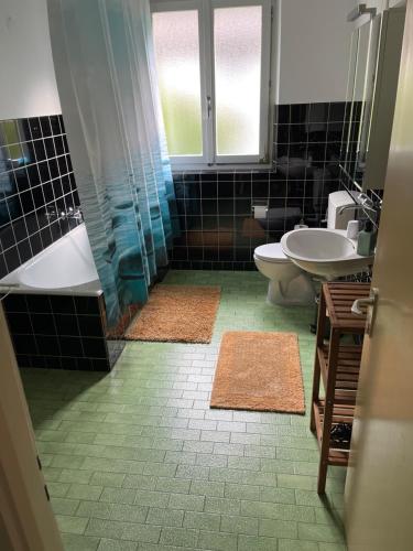 a bathroom with a tub and a sink and a toilet at Casa Silvia in Gordevio