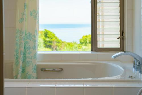 a bathroom with a bath tub and a window at Villa LIGHT HOUSE -館山 LIGHT HOUSE- ペット可 in Susaki