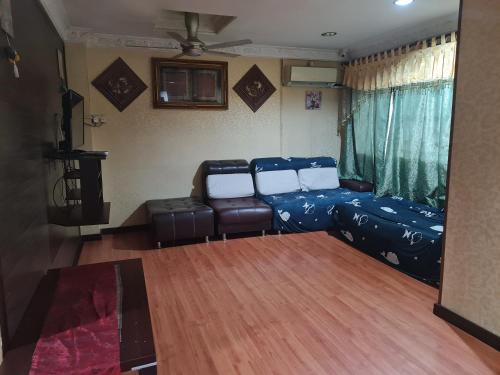 a living room with a bed and a couch at AnNur Homestay in Lahad Datu