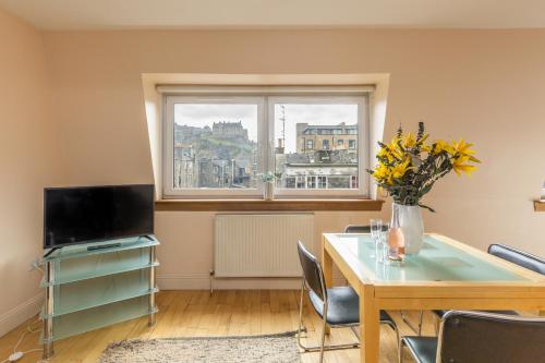 a living room with a table and a window at Amazing Castle View Apartment in Edinburgh