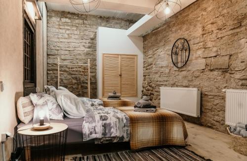 a bedroom with a bed and a stone wall at Narva Castle Rooms in Narva