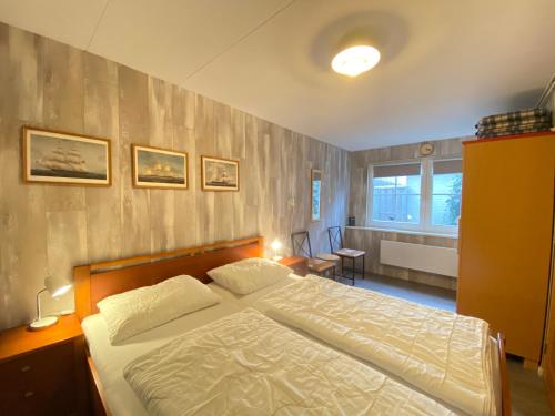 Un dormitorio con una cama grande y una ventana. en Op 't Landtweg 26, en Callantsoog