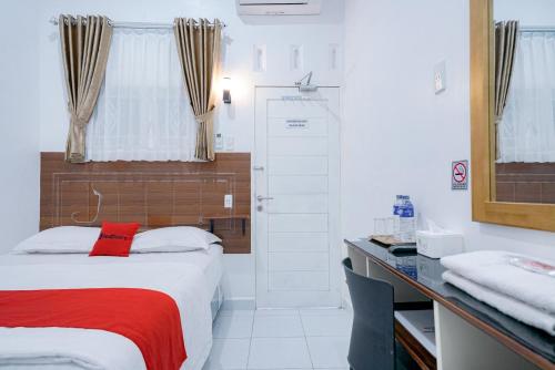 een slaapkamer met een bed met een rode deken bij RedDoorz near Pantai Pandan Sibolga in Halangan