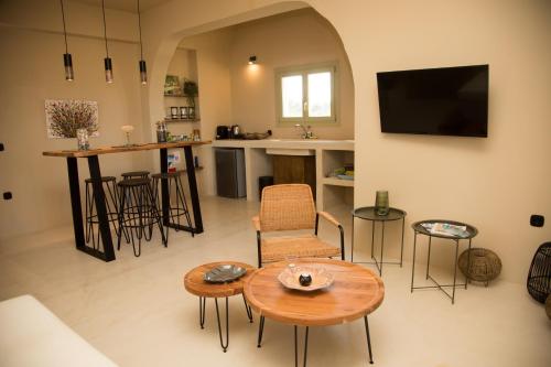 a living room with a table and chairs and a television at Olive Villa in Kamari