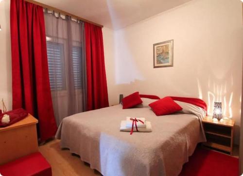 1 dormitorio con 1 cama con cortinas rojas en Apartment Lopud 17200a, en Lopud Island