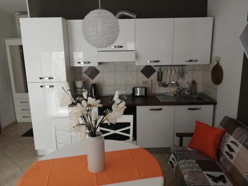 eine Küche mit einem Tisch und einer Blumenvase darauf in der Unterkunft Apartment Lopud 17200a in Lopud Island