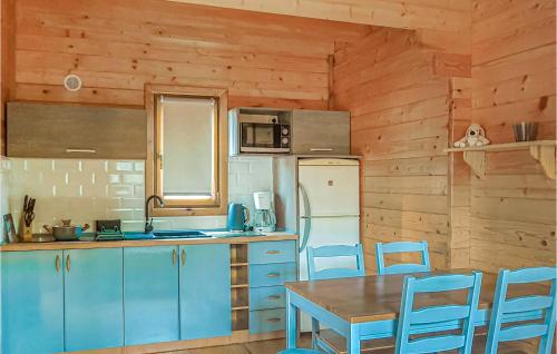 ムシチツェにあるStunning Home In Mscice With 2 Bedrooms And Wifiのキッチン(青いキャビネット、テーブル、椅子付)