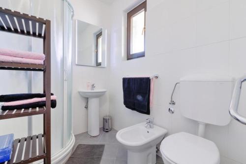 Apartments with a parking space Medulin - 17107 في ميدولين: حمام ابيض مع مرحاض ومغسلة