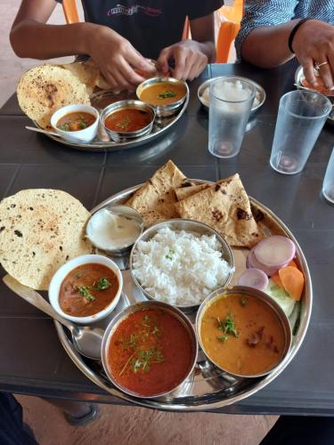 una mesa con platos de comida en una mesa en Omkar Agro Tourism & Resort, en Mahabaleshwar