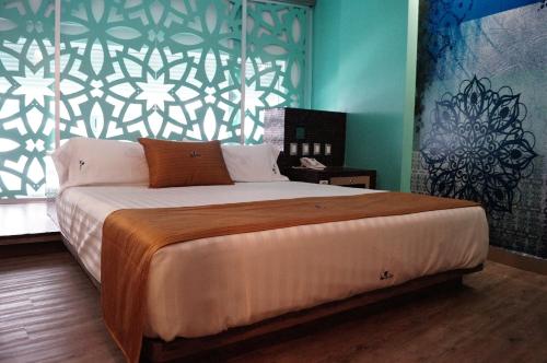 Hotel Amala في مدينة ميكسيكو: غرفة نوم بسرير كبير وبجدار