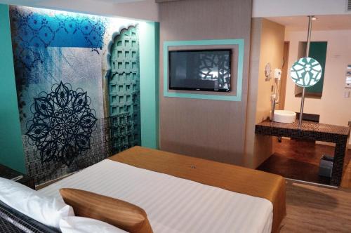 a bedroom with a bed and a tv on a wall at Hotel Amala in Mexico City