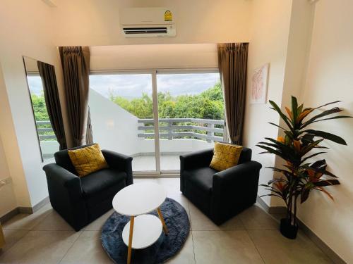 a living room with two chairs and a large window at Rayong Condo Chain studio room in Ban Pak Khlong Phe