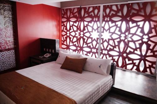 a bedroom with a bed with a red wall at Hotel Amala in Mexico City