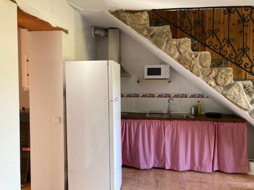 a white refrigerator in a kitchen with a table at Casas Rurales La Trufa Madre Casa 2 in Vega del Codorno