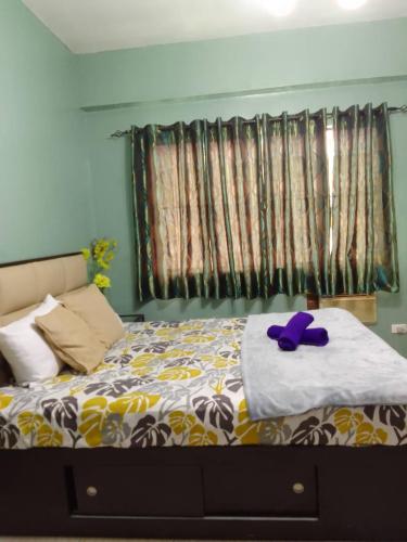 a bedroom with a bed with a purple stuffed animal on it at Affordable Transient in Valley Golf near Emperor Events Place in Cainta