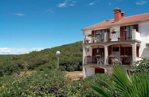 uma grande casa com uma varanda e uma montanha em Apartment Vrsar 17473b em Vrsar