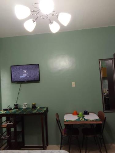 sala de estar con 2 mesas y TV en la pared en Affordable Transient in Valley Golf near Emperor Events Place, en Cainta