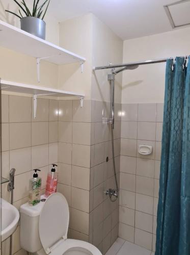 y baño con ducha, aseo y lavamanos. en Affordable Transient in Valley Golf near Emperor Events Place, en Cainta