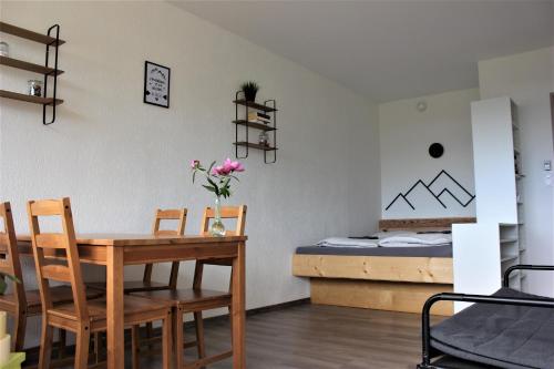 Zimmer mit einem Tisch, Stühlen und einem Bett in der Unterkunft Studio au cœur des Vosges avec une magnifique vue in La Bresse