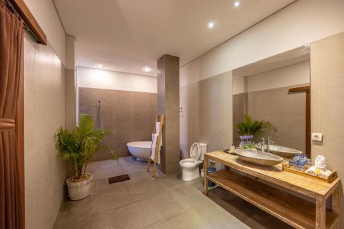 a bathroom with a sink and a toilet and a tub at Green Oasis Private Villa in Ubud