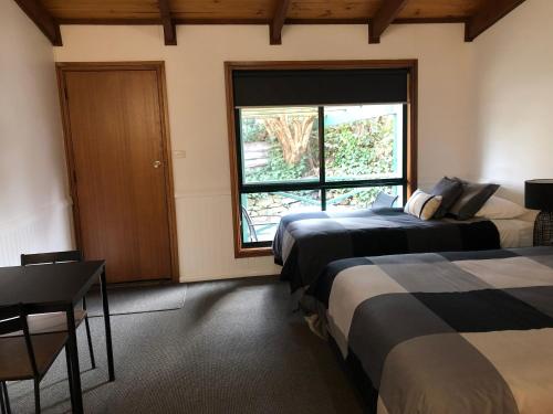 um quarto com duas camas e uma janela em Black Range Lodge em Tumbarumba