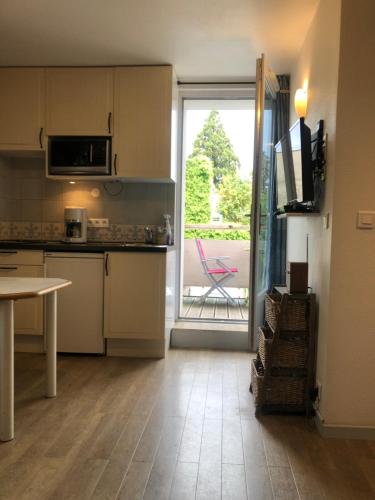une cuisine avec une table et une porte donnant sur une terrasse. dans l'établissement studio 6 Versoie avec parking, à Thonon-les-Bains