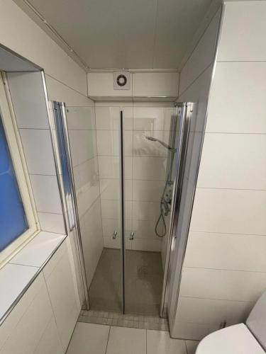 a shower with a glass door in a bathroom at Waterfront Senja 2 in Torsken