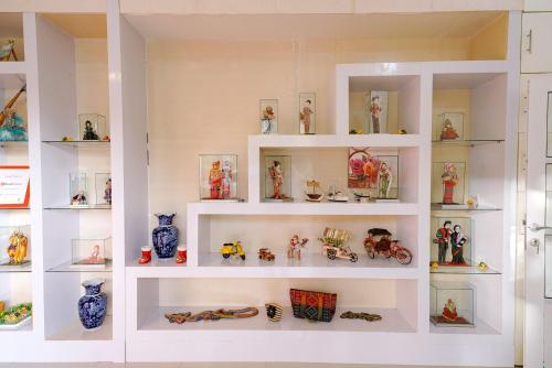 a white shelf filled with lots of action figures at RedDoorz Plus @ Jalan FL Lumban Tobing Sibolga in Sibolga