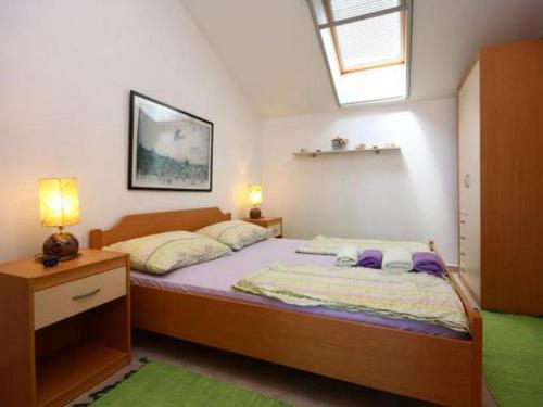 a bedroom with a large bed and a window at Family friendly seaside apartments Krapanj, Sibenik - 18004 in Šibenik
