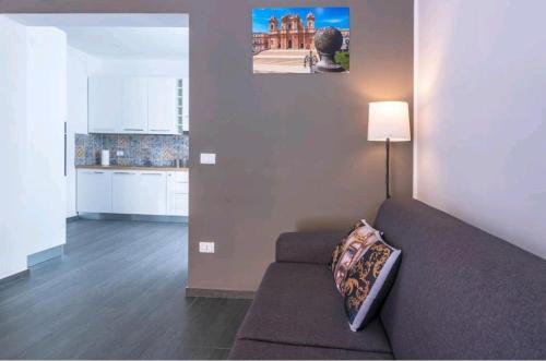 een woonkamer met een bank en een keuken bij La casa di Alessandro in Noto