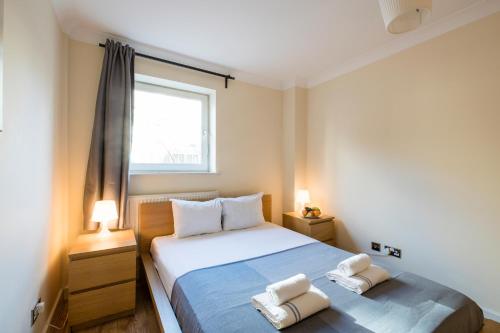 a bedroom with a bed with two towels on it at Stay Saint Paul's in London