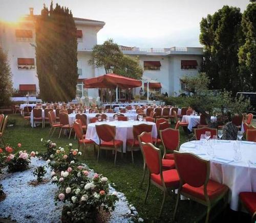 un gruppo di tavoli e sedie di fronte a un edificio di The Regent Boutique Hotel & Spa PRE OPENING a San Marino