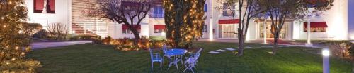 un cortile con sedie e tavolo di fronte a un edificio di The Regent Boutique Hotel & Spa PRE OPENING a San Marino