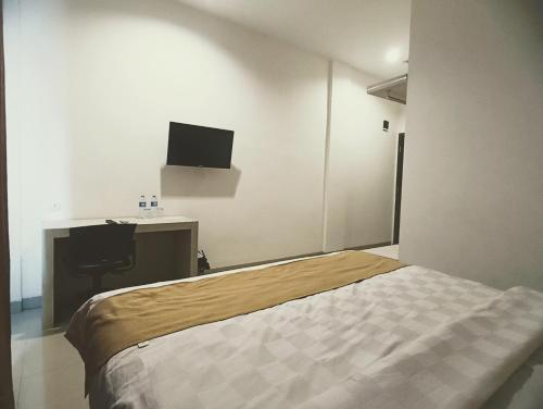 a bedroom with a bed and a tv on the wall at Yunna Express in Geruntang