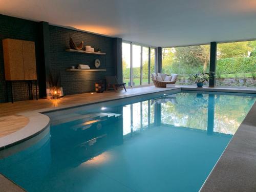 a large swimming pool in a room with windows at Villa Geva in Montignies-le-Tilleul