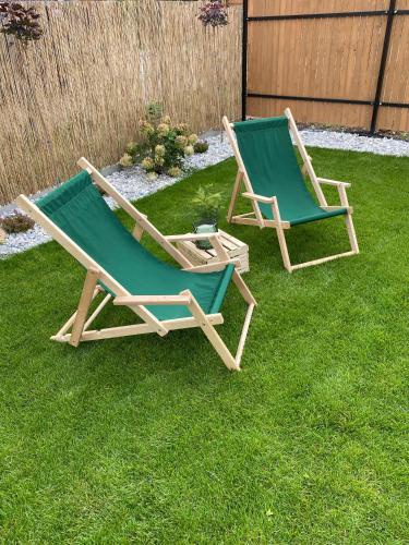 two lawn chairs sitting on the grass in a yard at Folkova 21 - Apartamenty in Biały Dunajec