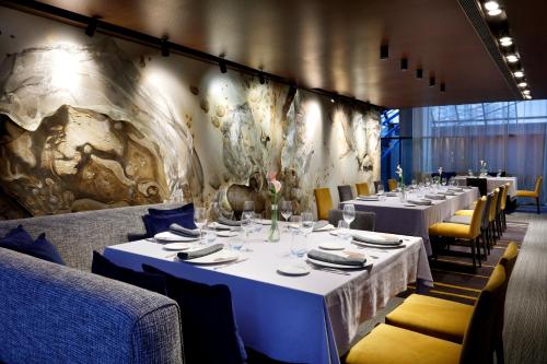 a dining room with white tables and yellow chairs at Hesperia Fira in Hospitalet de Llobregat