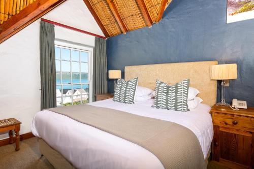 ein Schlafzimmer mit einem großen Bett und einem Fenster in der Unterkunft Adventure Pad's by The Farmhouse Hotel in Langebaan