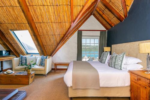 a bedroom with a large bed and a couch at Adventure Pad's by The Farmhouse Hotel in Langebaan