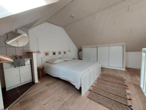 sypialnia z białym łóżkiem na poddaszu w obiekcie Appartement Duplex très lumineux en centre ville w mieście Janzé