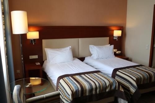 two beds sitting next to each other in a hotel room at Młyn Jacka Hotel & Spa in Wadowice