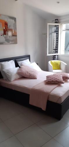 1 dormitorio con 1 cama grande con sábanas y almohadas rosas en mas saint genieis, en Canet